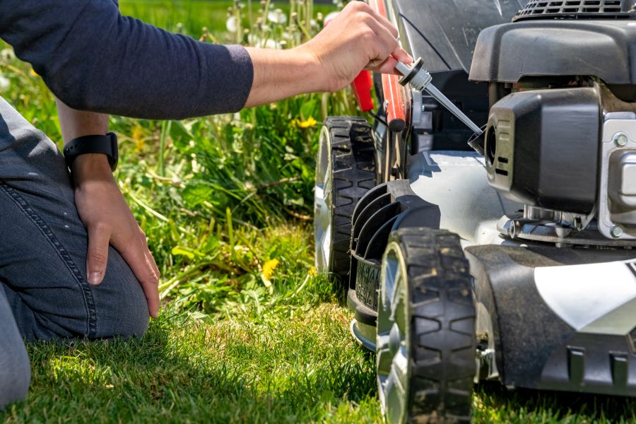 Man checking oil in his motor lawn mower