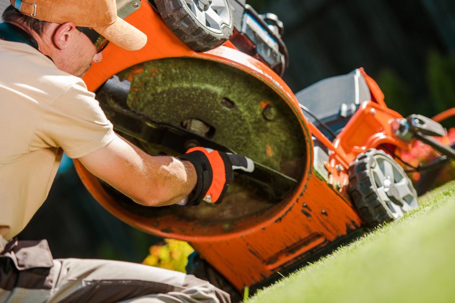 Gardener checking his lawn mower blade